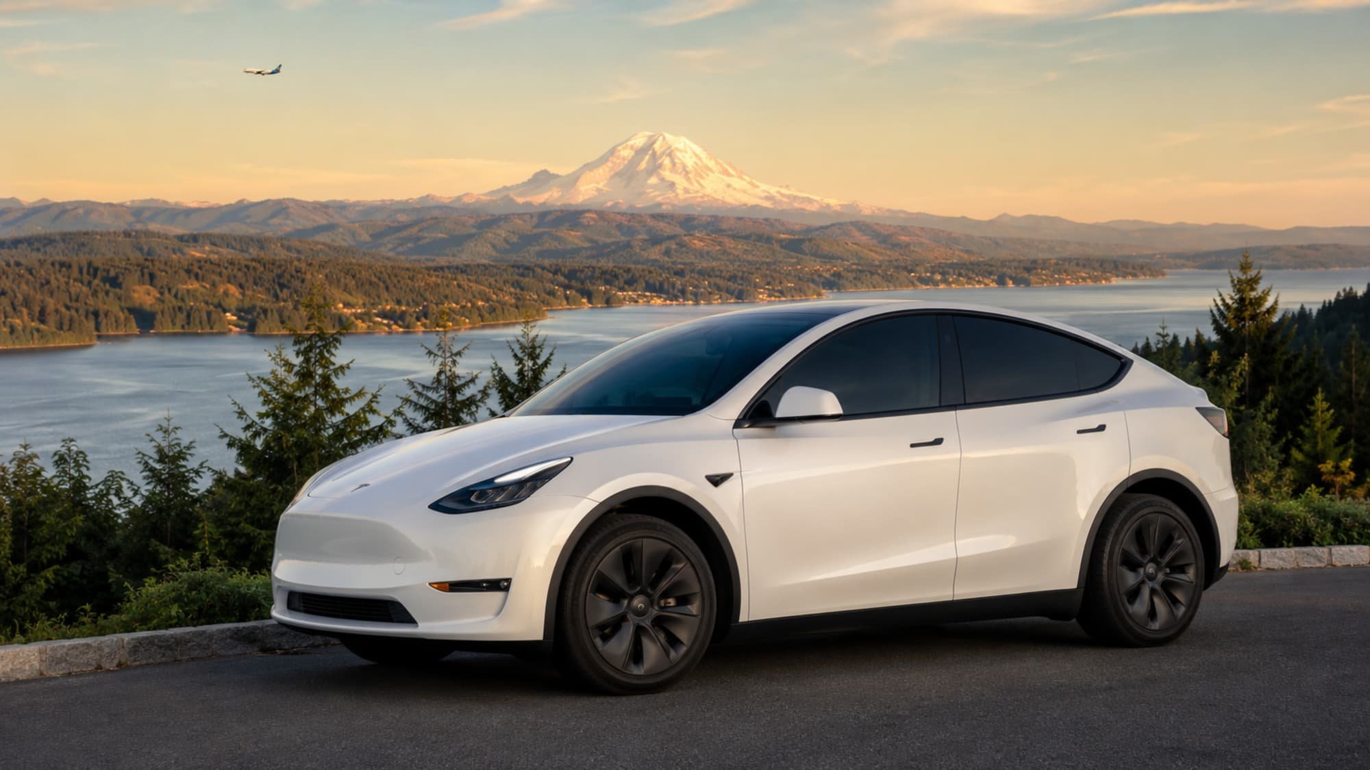 Pearl White Tesla Model Y used by Freedom Rides at a Lake Tapps overlook, with Mount Rainier in the distance.